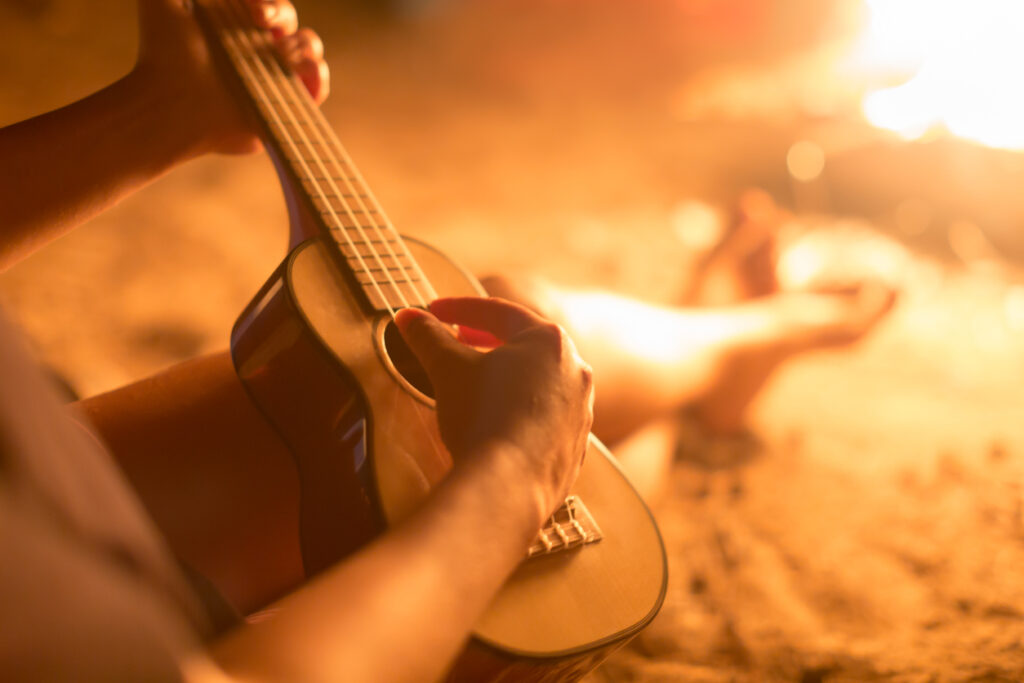 Strumming an ukulele in front of a fireplace